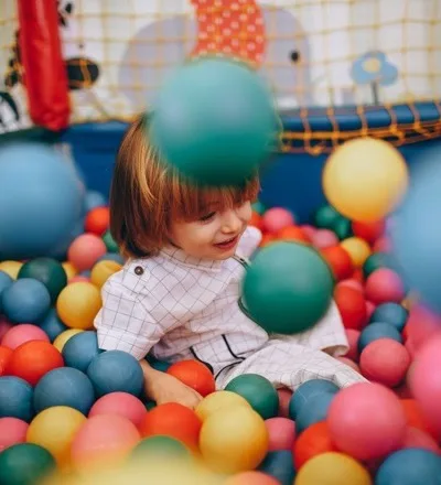 Bambina che gioca nella piscina di palline
